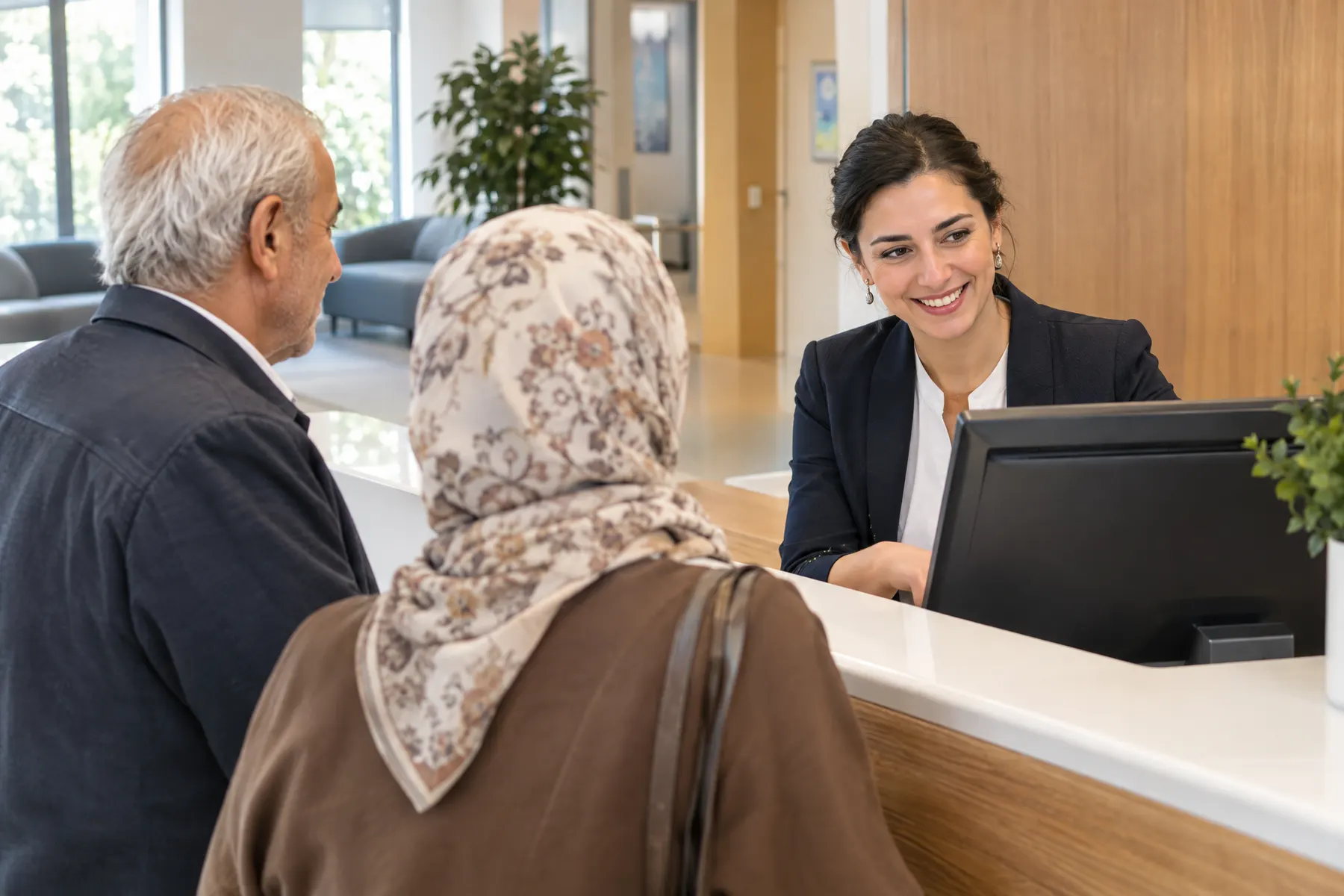 Poliklinik resepsiyonunda yaşlı bir çifti karşılayan görevli